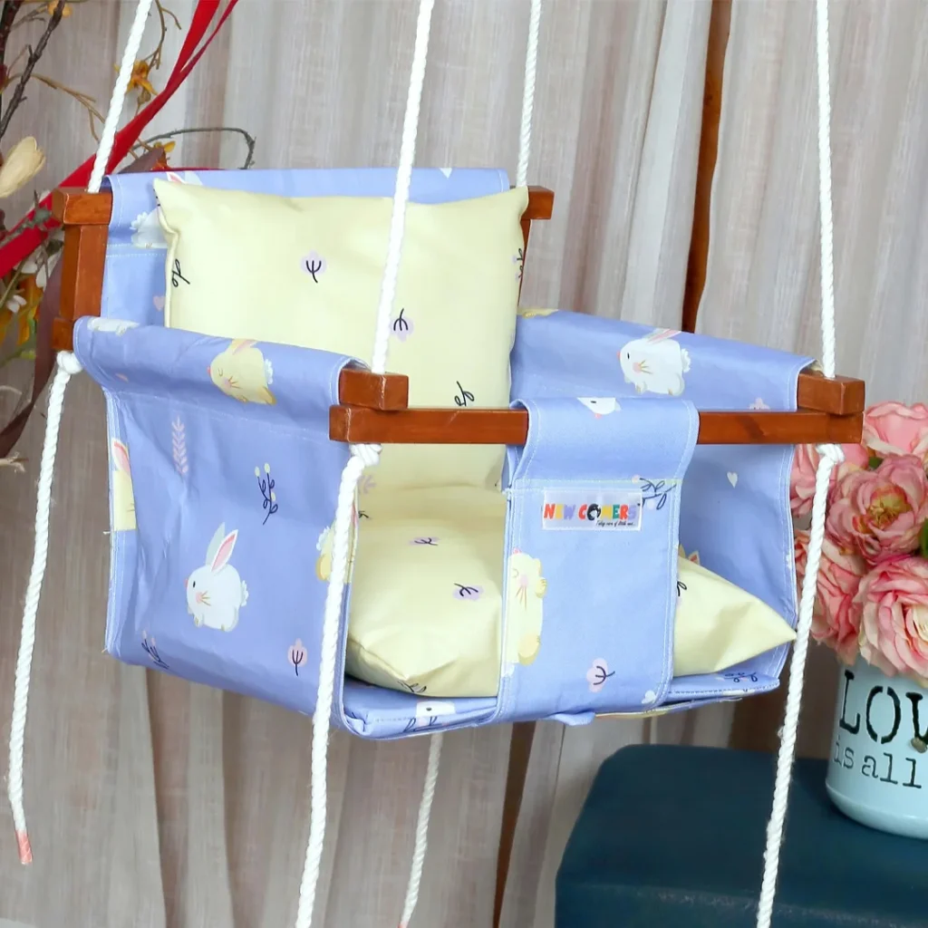 Purple colored fabric with white rabbit print baby swings with wooden frames, with 2 pcs of yellow print pillows for sitting and back support