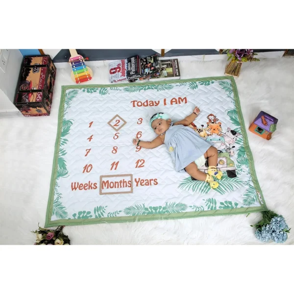 green white organic cotton crib quilt with cartoon prints milestone blanket with baby girl sleeping on it by newcomers