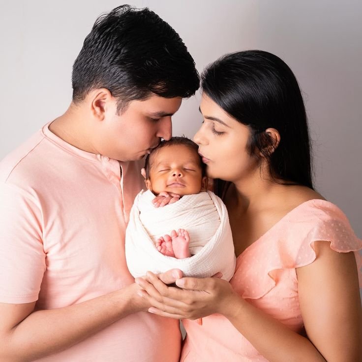 Newborn photoshoot with parents craddle pose