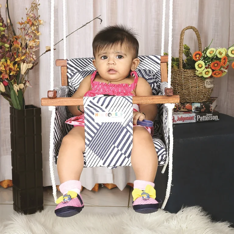 baby sitting on Adjustable baby swing with wooden frame. Dive into our collection of adjustable baby swings with durable wooden frames, tailor-made for your little one's utmost comfort and joy.